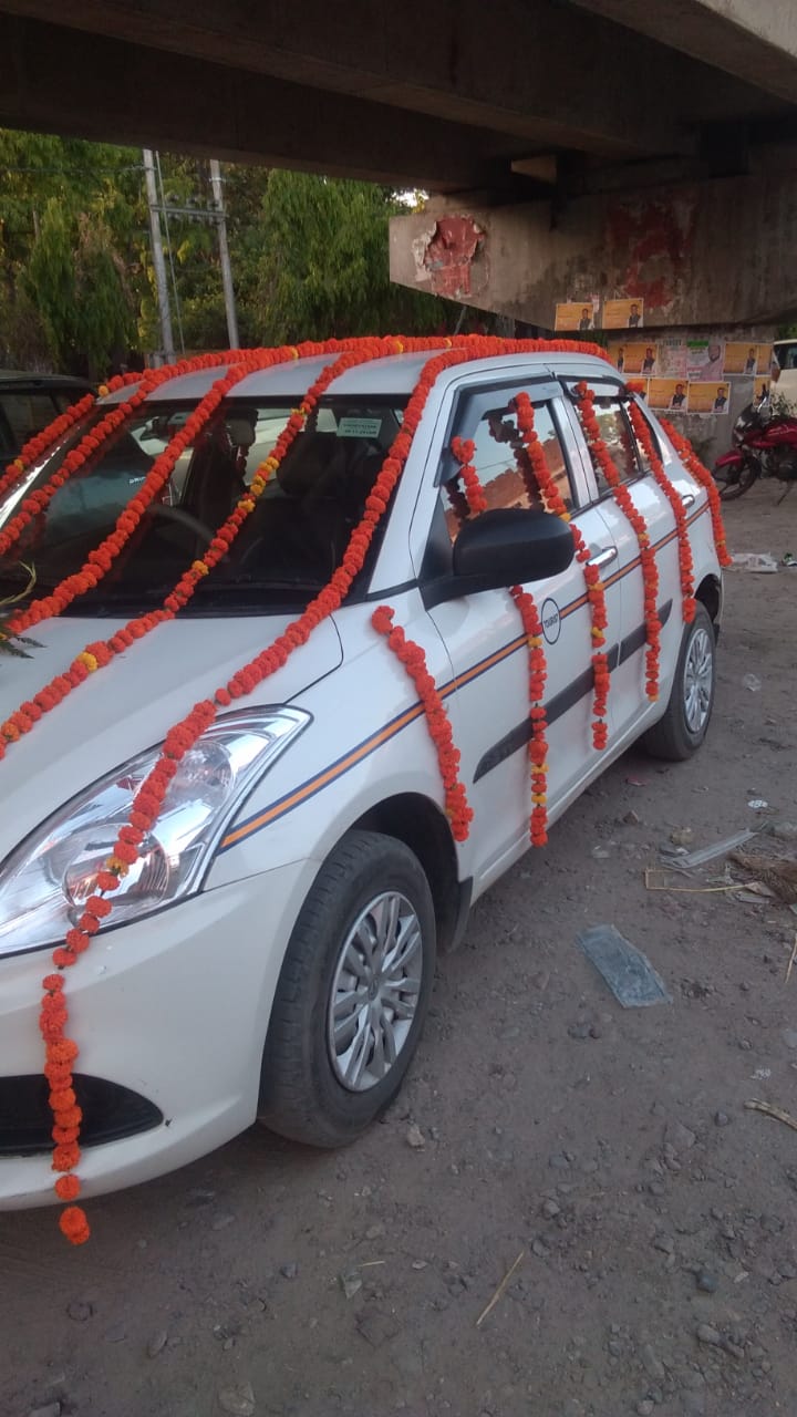 Maruti Swift decorated with marigold garlands for celebration