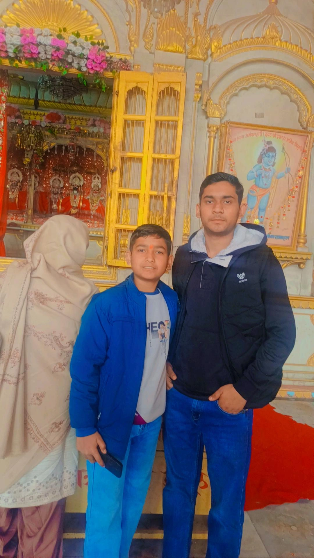 Visitors at ornate temple with golden architecture during pilgrimage tour