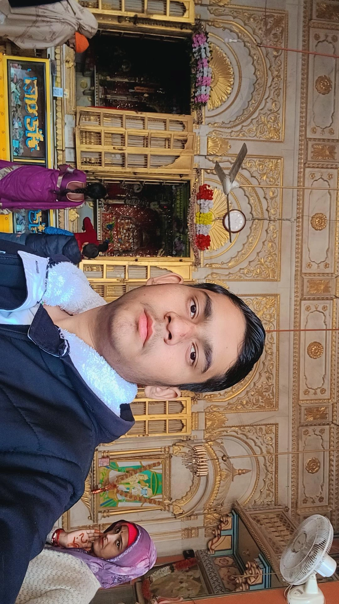 Temple visitors inside ornate shrine with golden architecture